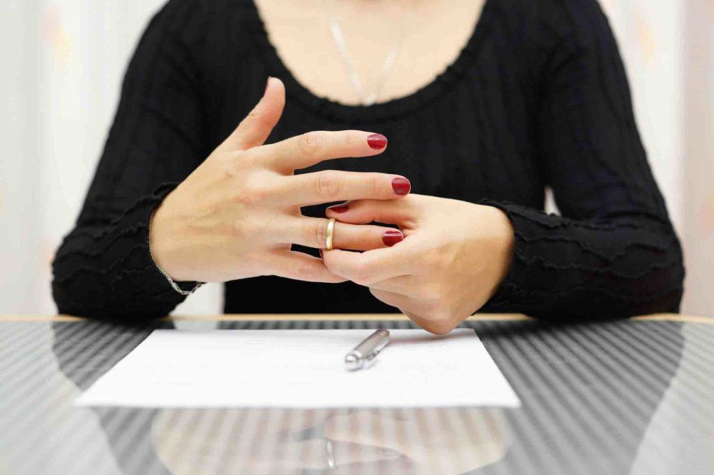 Frau nimmt Ring vom Finger